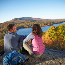 Hikers overlooking a lake from atop Mount Monadnock in New Hampshire