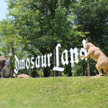 People at the welcome sign of Dinosaur Land in White Post, Virginia