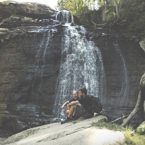 Hikers taking a rest in front of a waterfall in Cuyahoga Valley National Park in Ohio