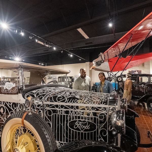 Two visitors admiring the collection at the Gilmore Car Museum in Hickory Corners, Michigan